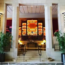 Marble lobby, stone stairs and pillars up to illuminated orange Art Deco style bar