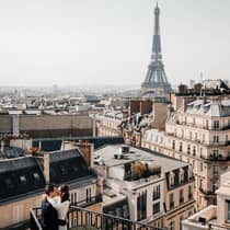 Couple embracing on Paris Hotel terrace with Eiffel Tower view