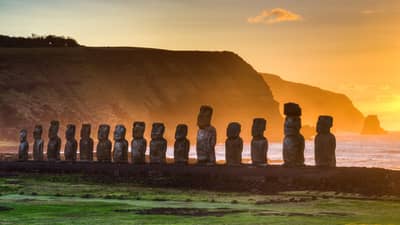 Stone statues of Easter Island in the sunset