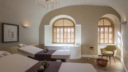 Vltava spa couples massage room with beds side-by-side, spa tub in front of window