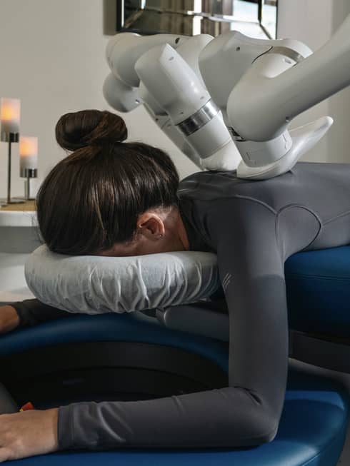 A guest laying on a massage table while getting a machined-powered massage