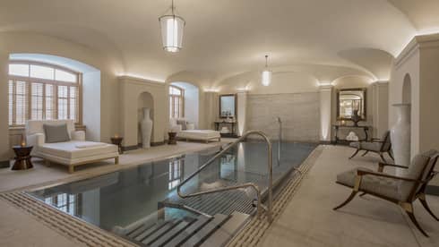 AVA Spa vitality pool flanked by white lounge chairs under domed ceiling