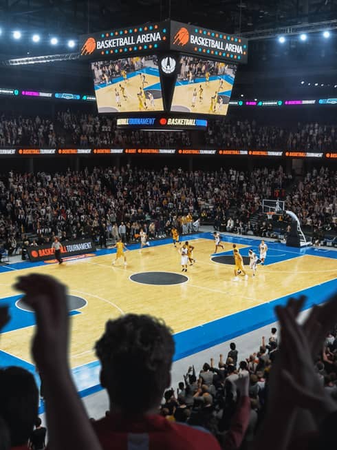 Professional basketball game being watched by a stadium full of people