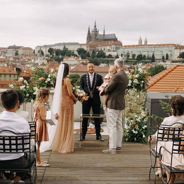 A beautiful wedding ceremony taking place on a rooftop, with guests enjoying the scenic city skyline in the background.