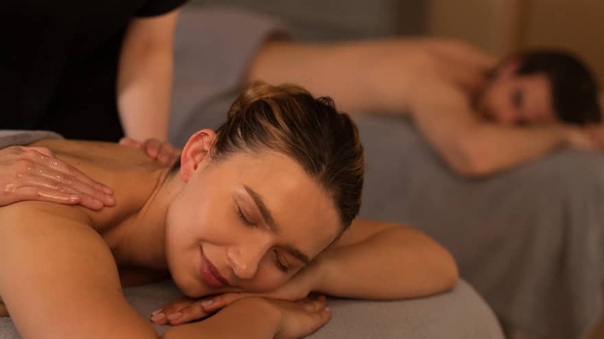 Two people laying on massage tables getting a massage.