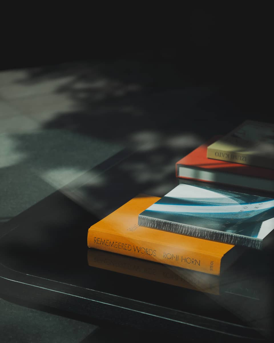 Orange, blue, red and green books stacked on a table