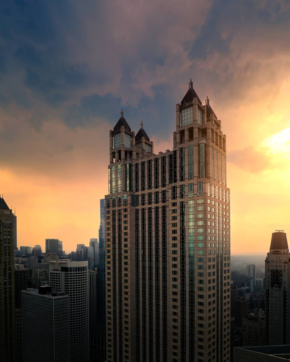 A tall building with a sunrise behind it.