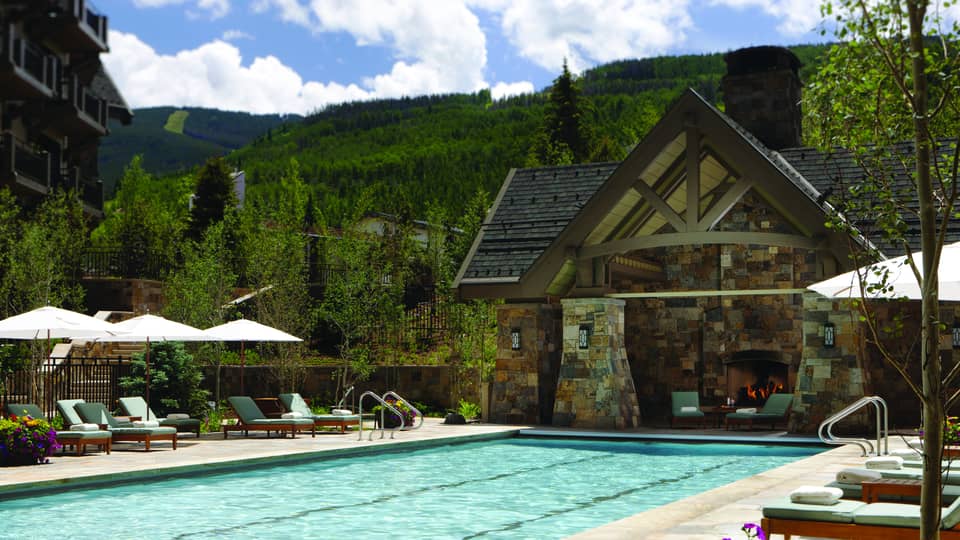 Outdoor lap pool at Four Seasons Resort Vail, lined with lounge chairs