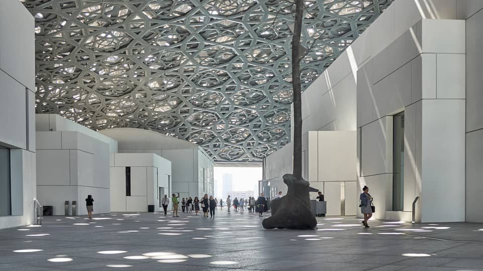 A large sculpture inside of a white stone building.