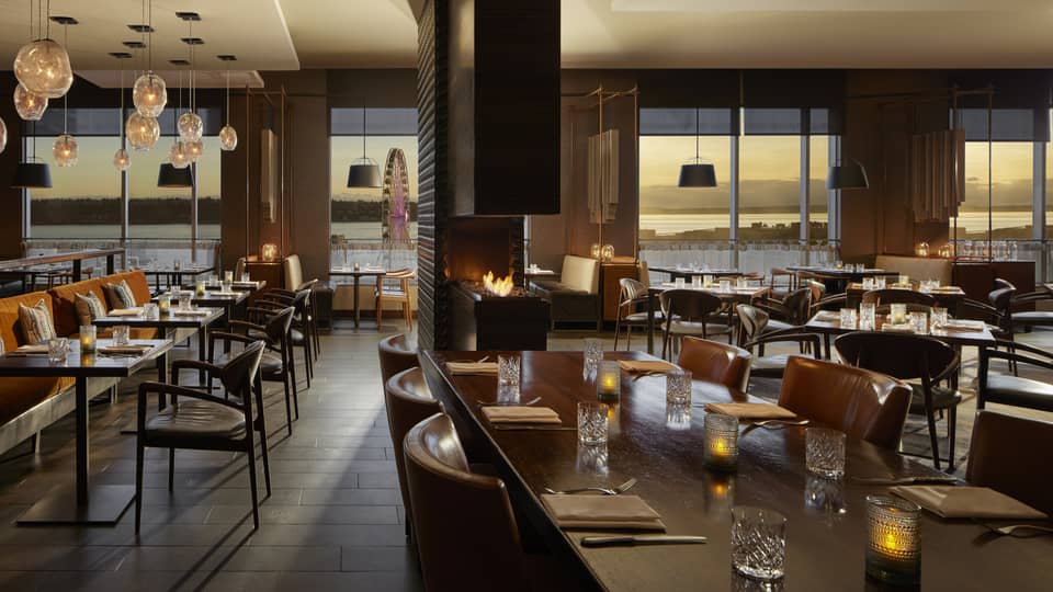 A dimly lit restaurant with large windows.