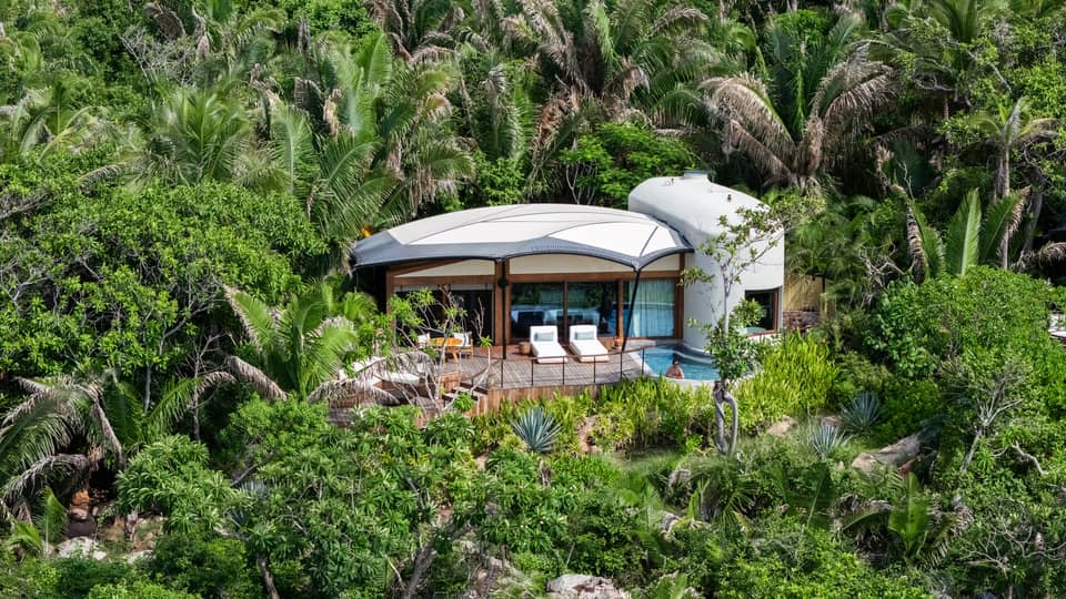 Secluded bungalow set in a lush, green tropical landscape