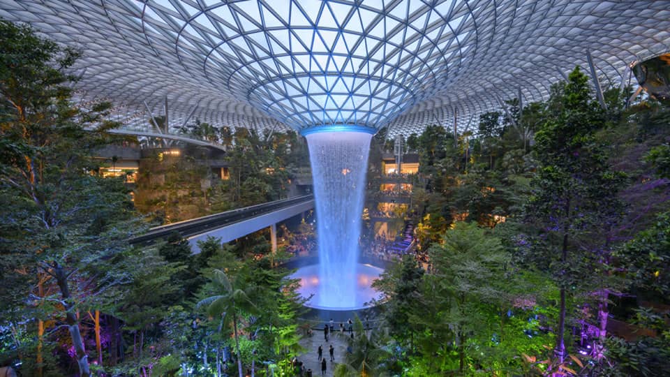 An arial view of an indoor garden with a large fountain in the center in singapore