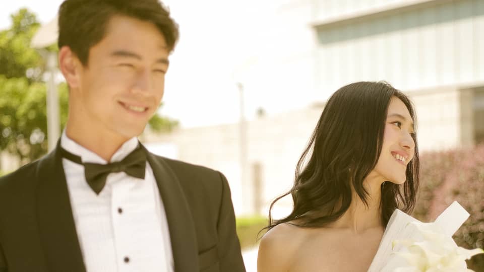 Bride and groom walk hand in hand outside in urban setting