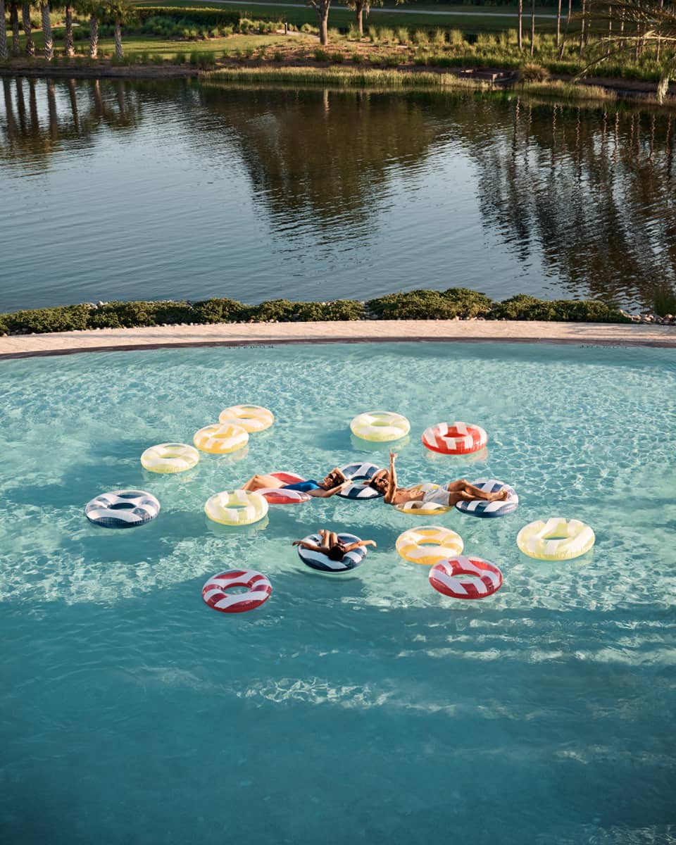 Guests floating on floats in a pool.