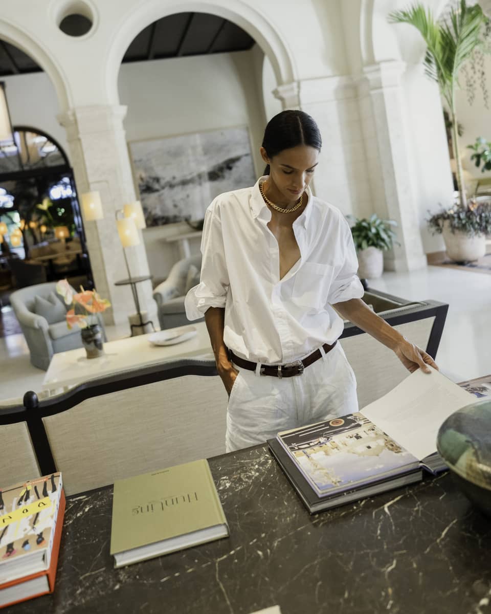 A person standing at a table and turning the pages of a book