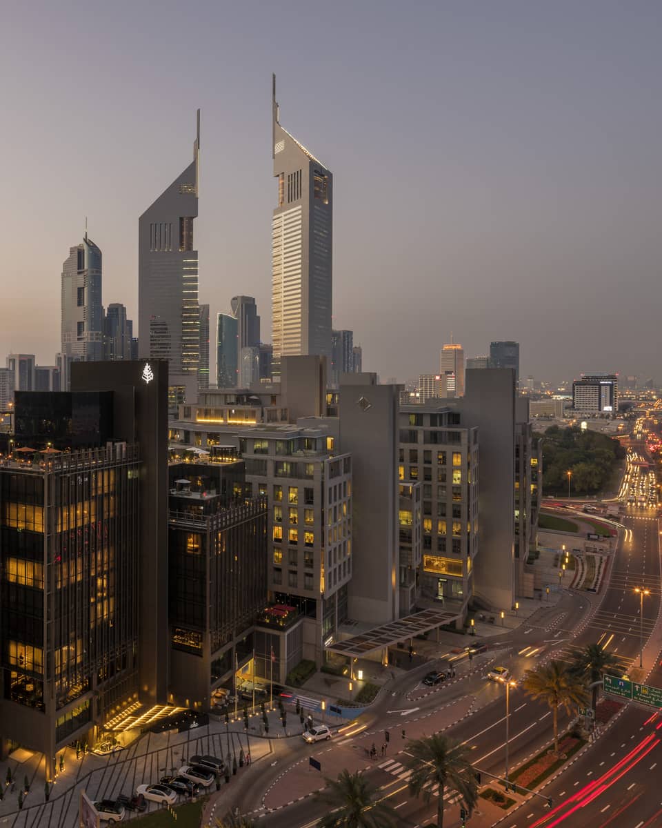 Aerial view of Dubai city skyline, road, lights around Four Seasons International Financial Centre hotel at sunset