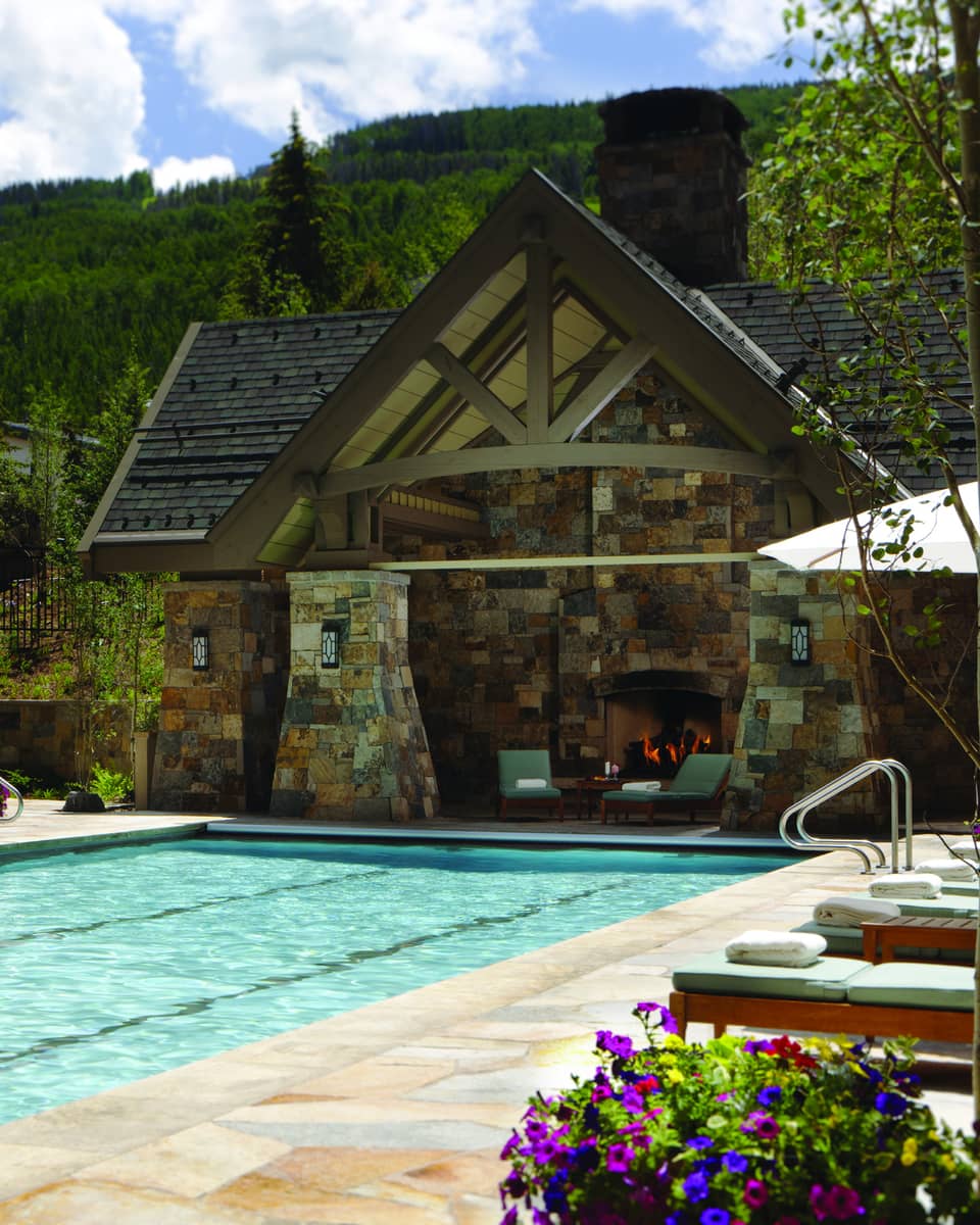 Outdoor lap pool at Four Seasons Resort Vail, lined with lounge chairs