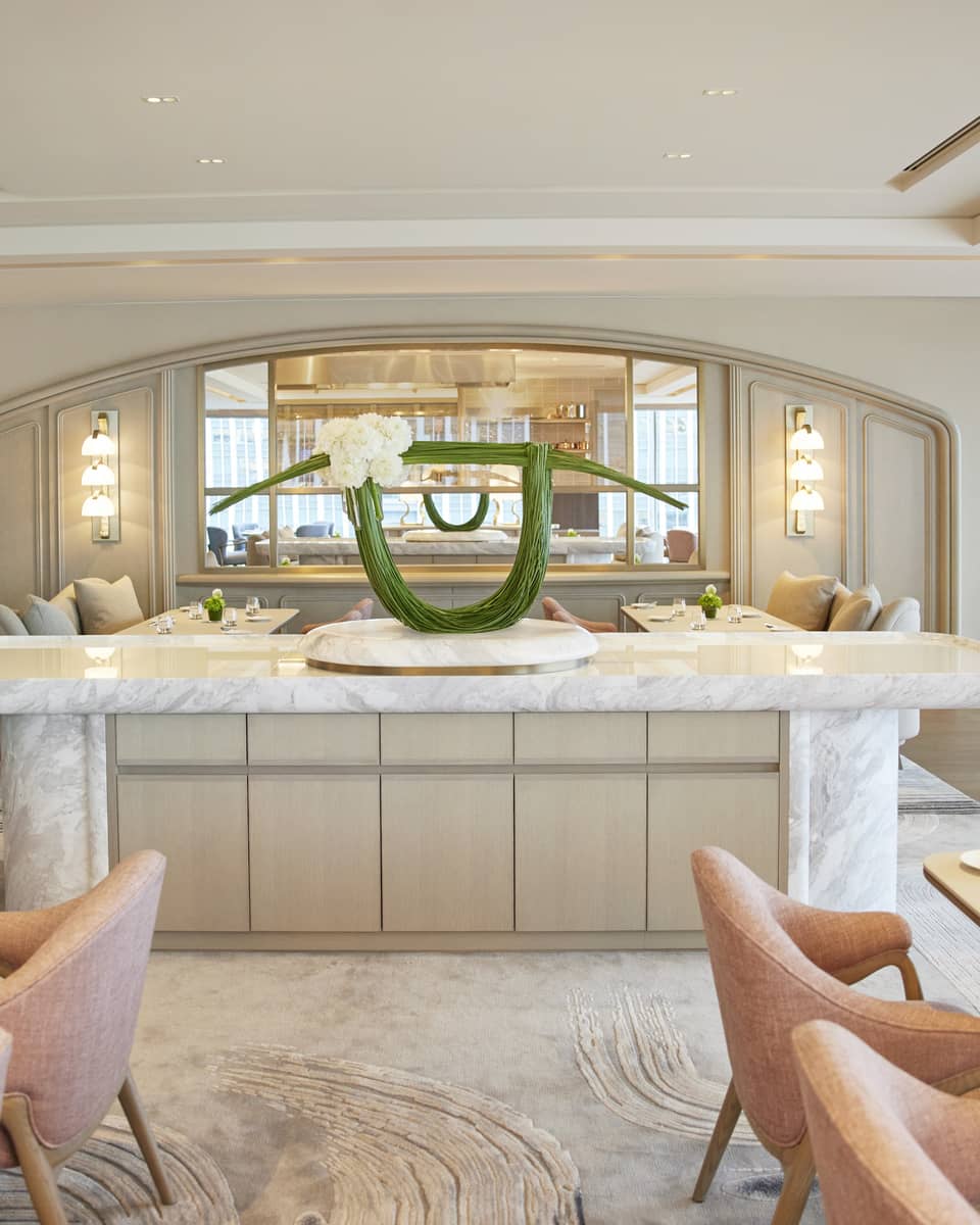 Four Seasons dining area with a marble counter and a modern floral arrangement in a light, stylish interior