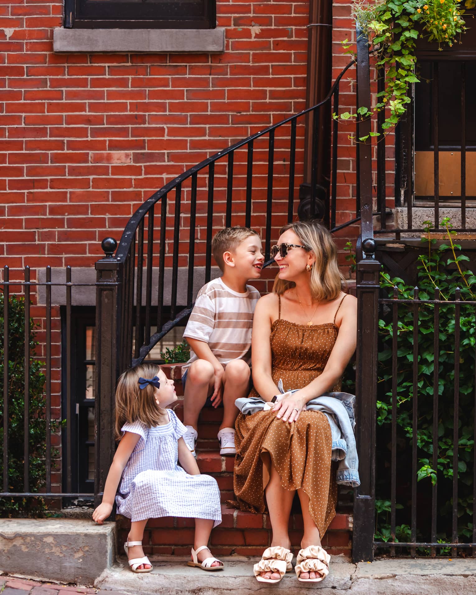 One guest sits on steps outdoors with two younger guests.