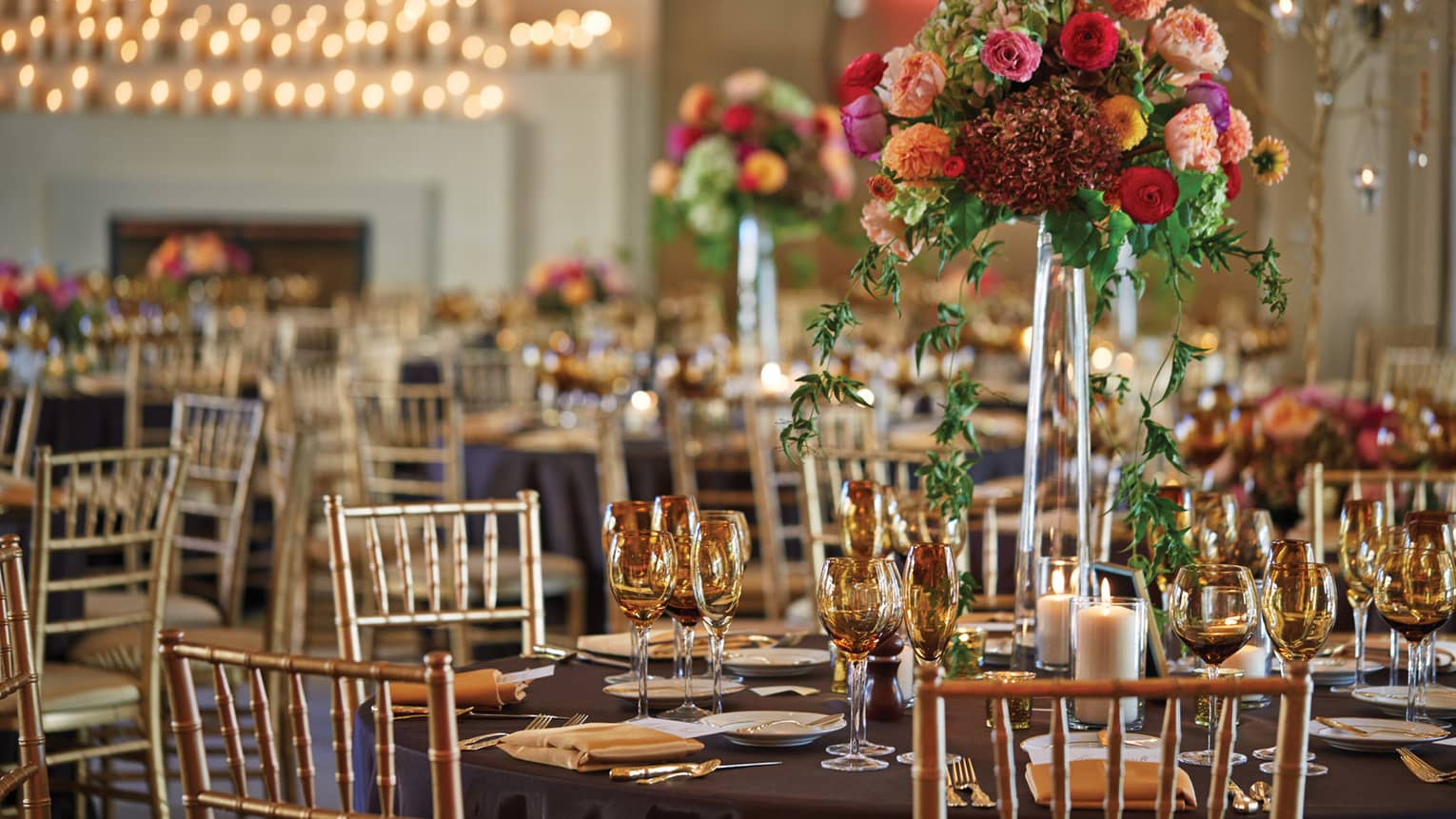 Colourful flowers on elegant wedding reception banquet table with amber glassware