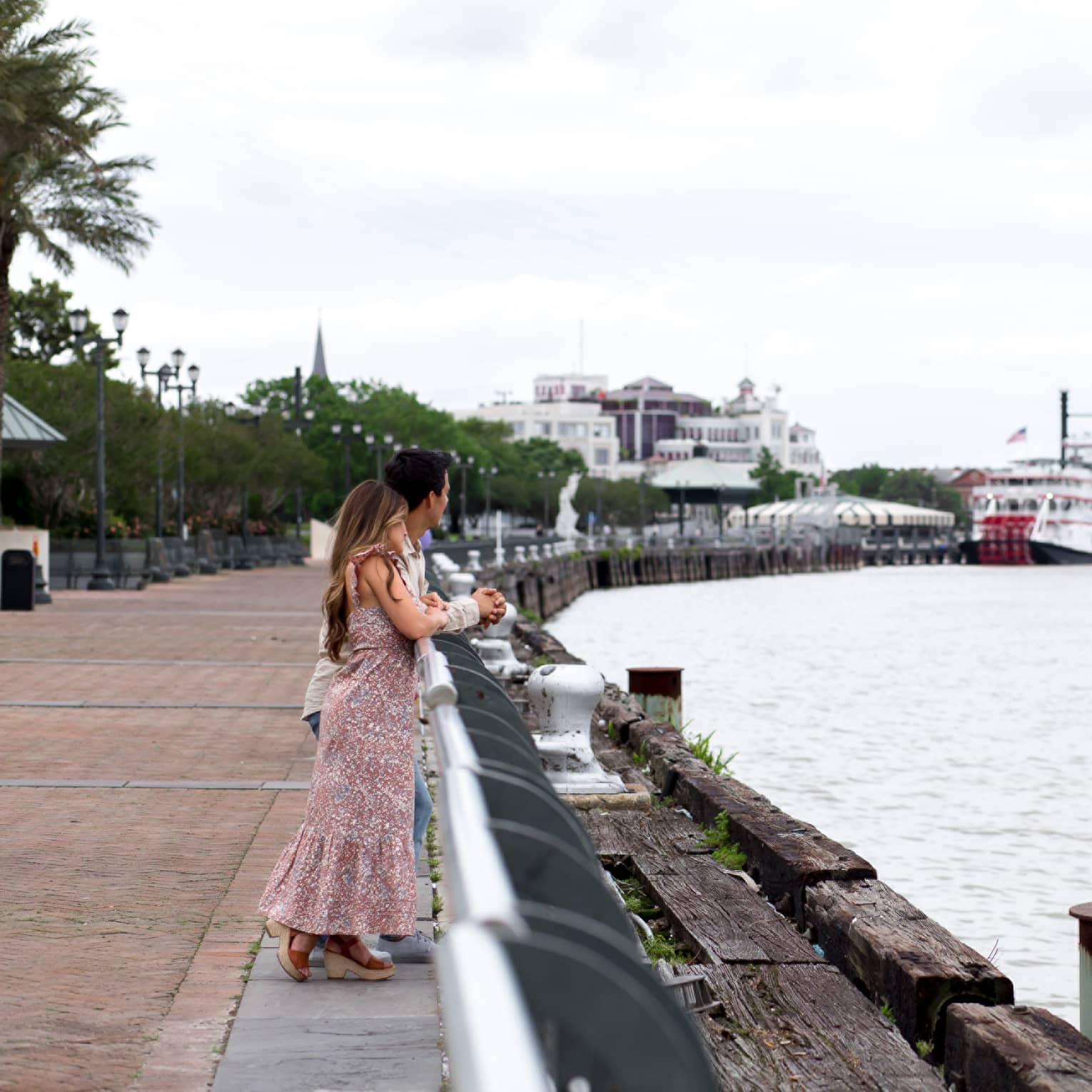 A woman and man looking out a river.