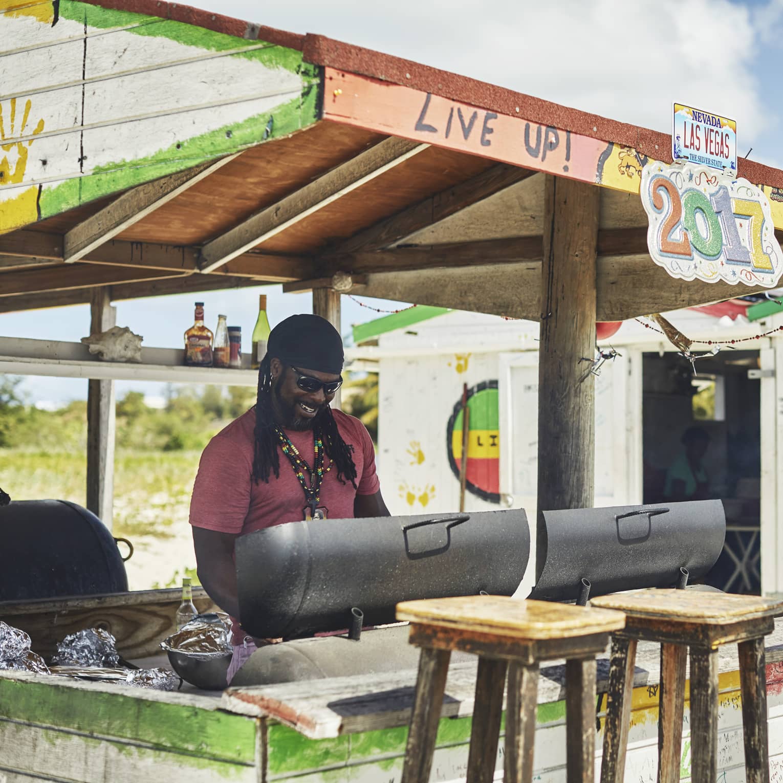 Smiling man grilling at colourful outdoor barbecue stand