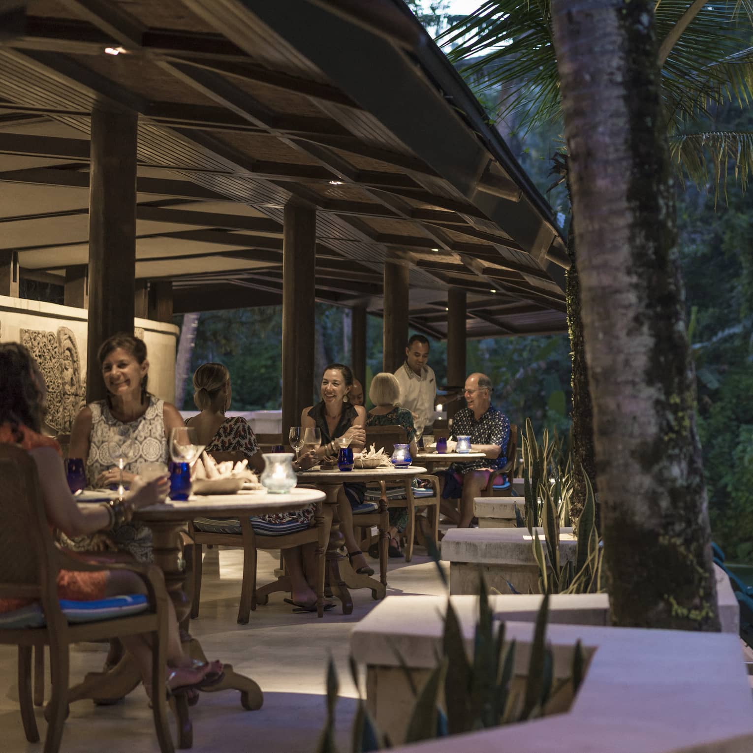 Guests enjoying dinner adjacent to a river in Bali
