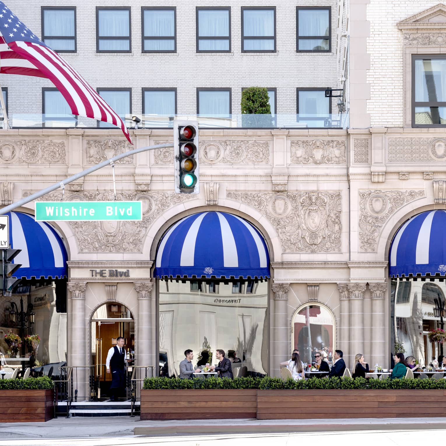 A patio where people are eating outside of a stone building.