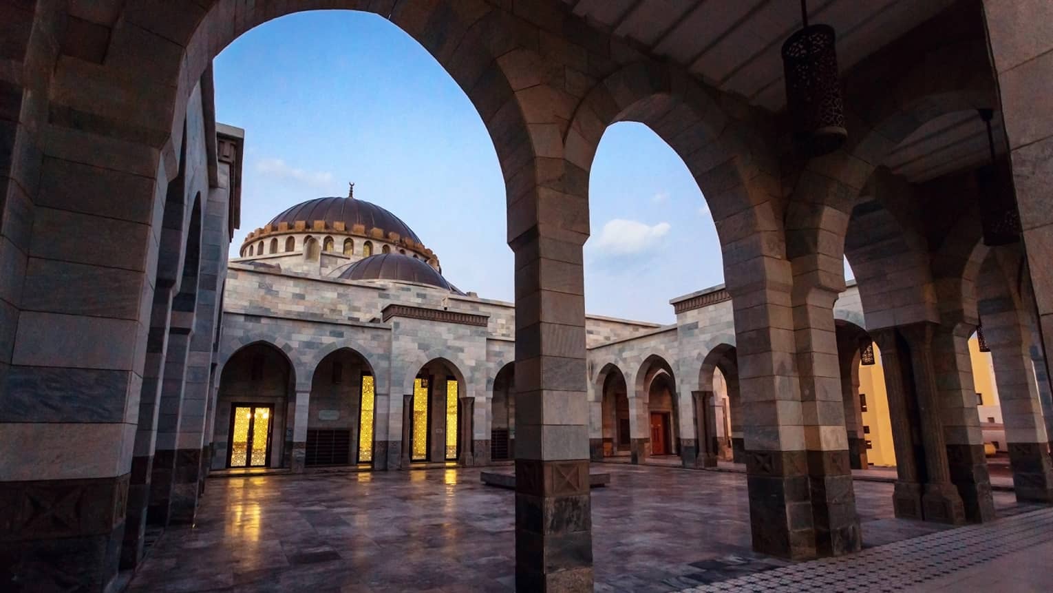 A series of grey columns above a tiled floor.