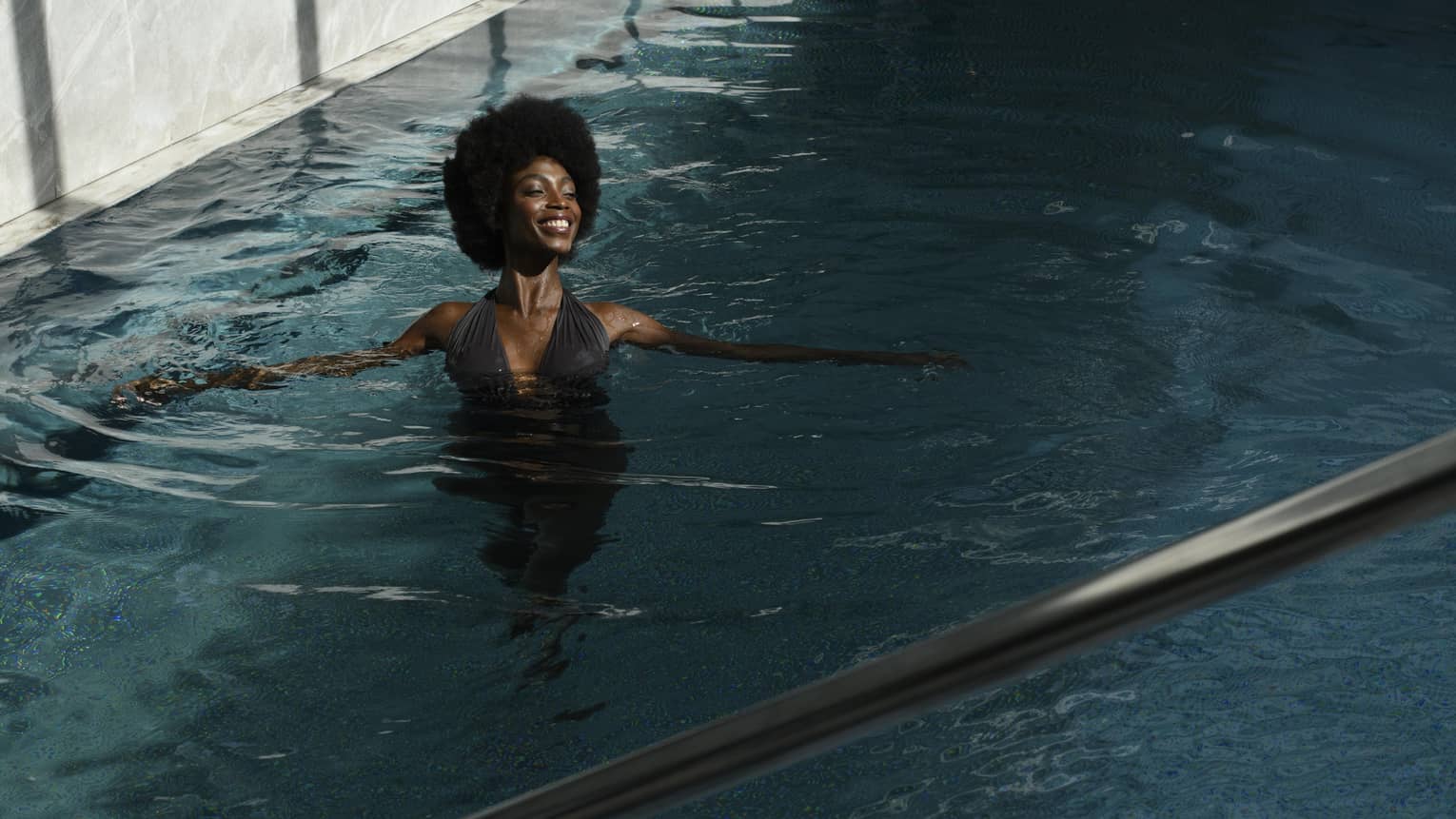 Woman wading in spa pool, smiling