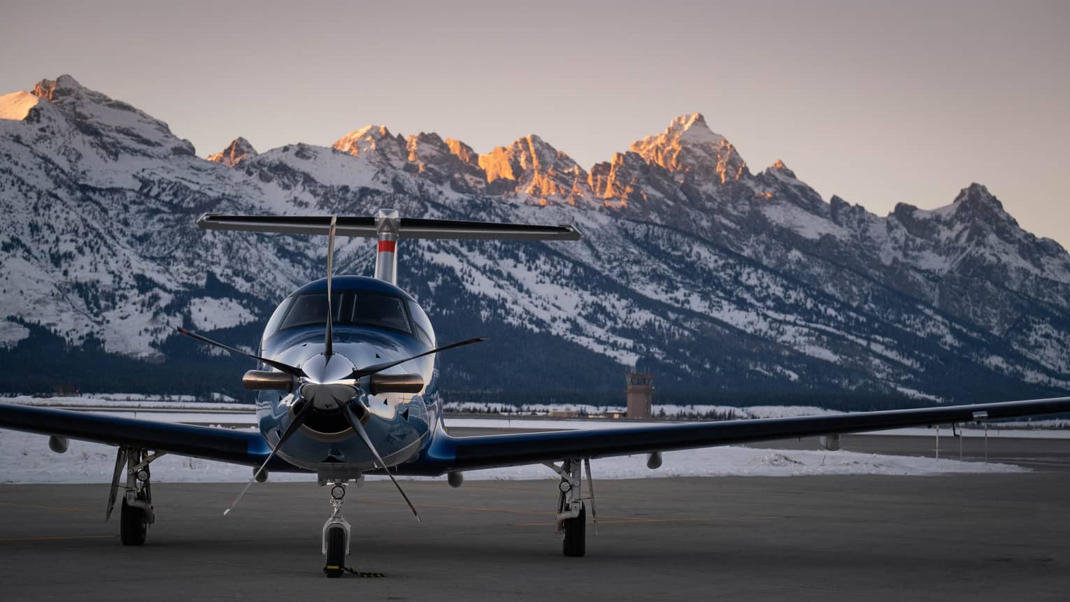 Airplane getting ready to take off with mountains in the background.
