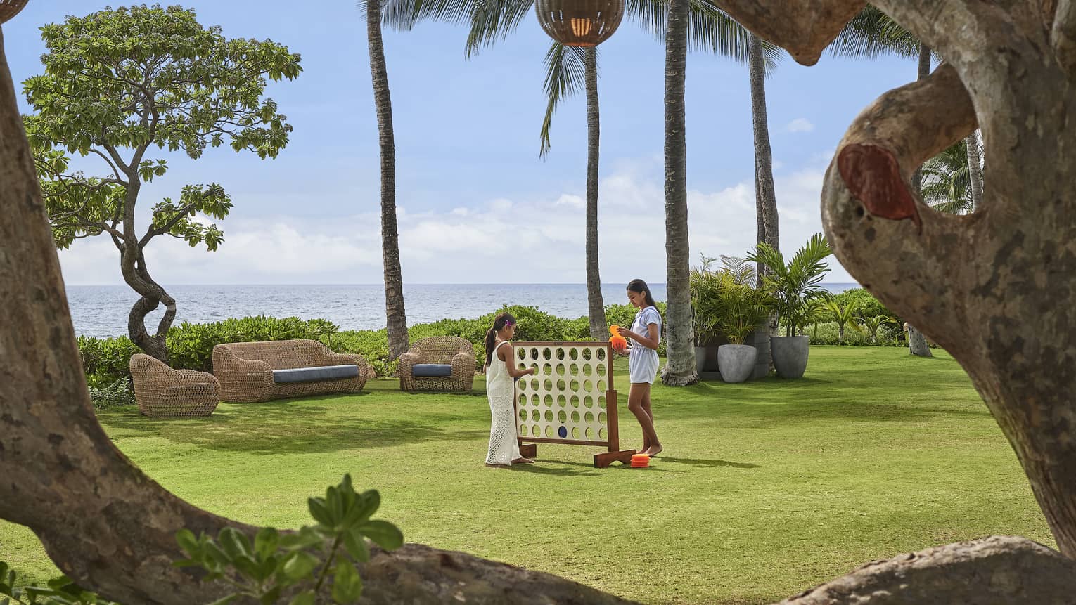 Two sisters play oversized Connect Four on the Resort lawn