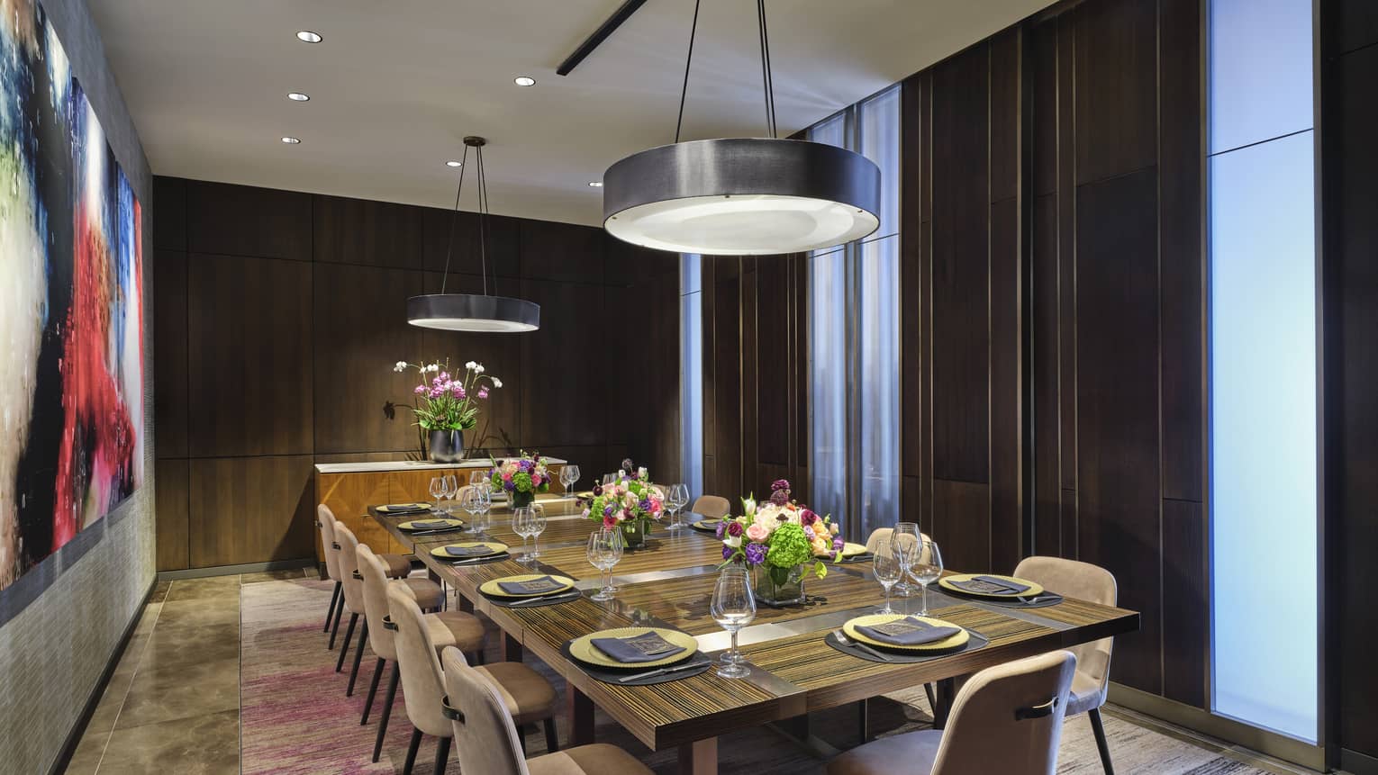 Room with table in the centre of the room and two circular lights above.