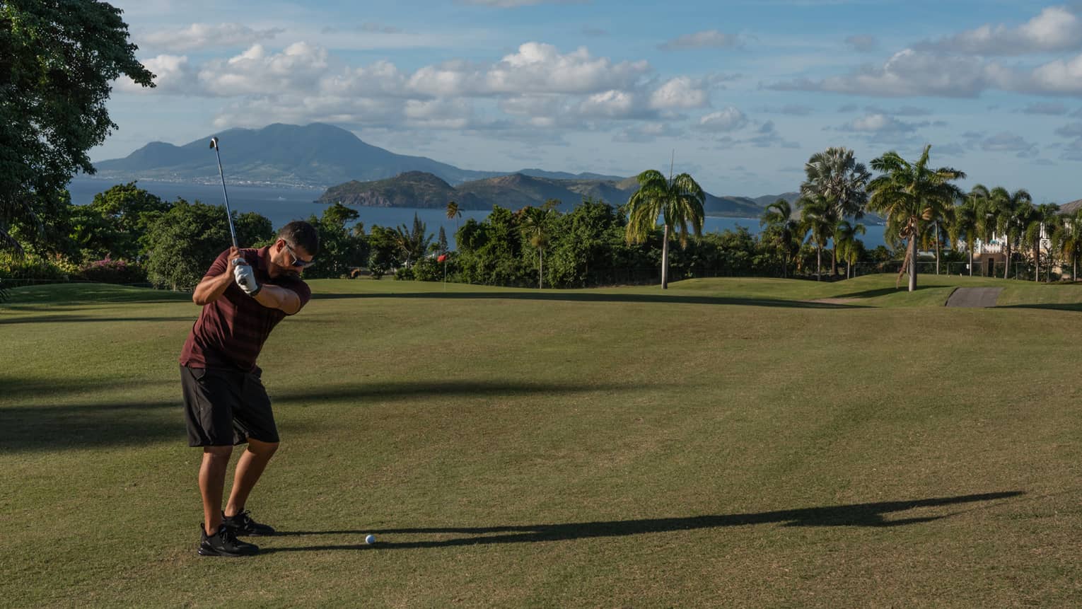 A person swinging a golf club on a golf course