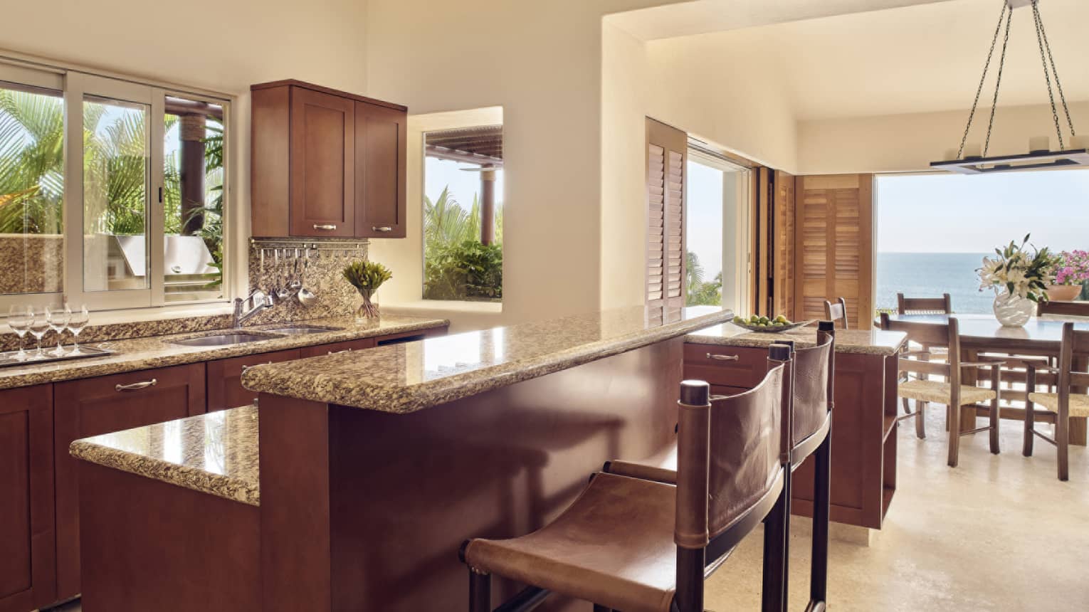 Kitchen with dark wood cabinetry, two counter chairs