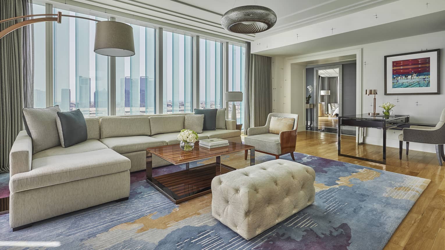 A plush couch sits atop a colourful rug in the Premier King Suite
