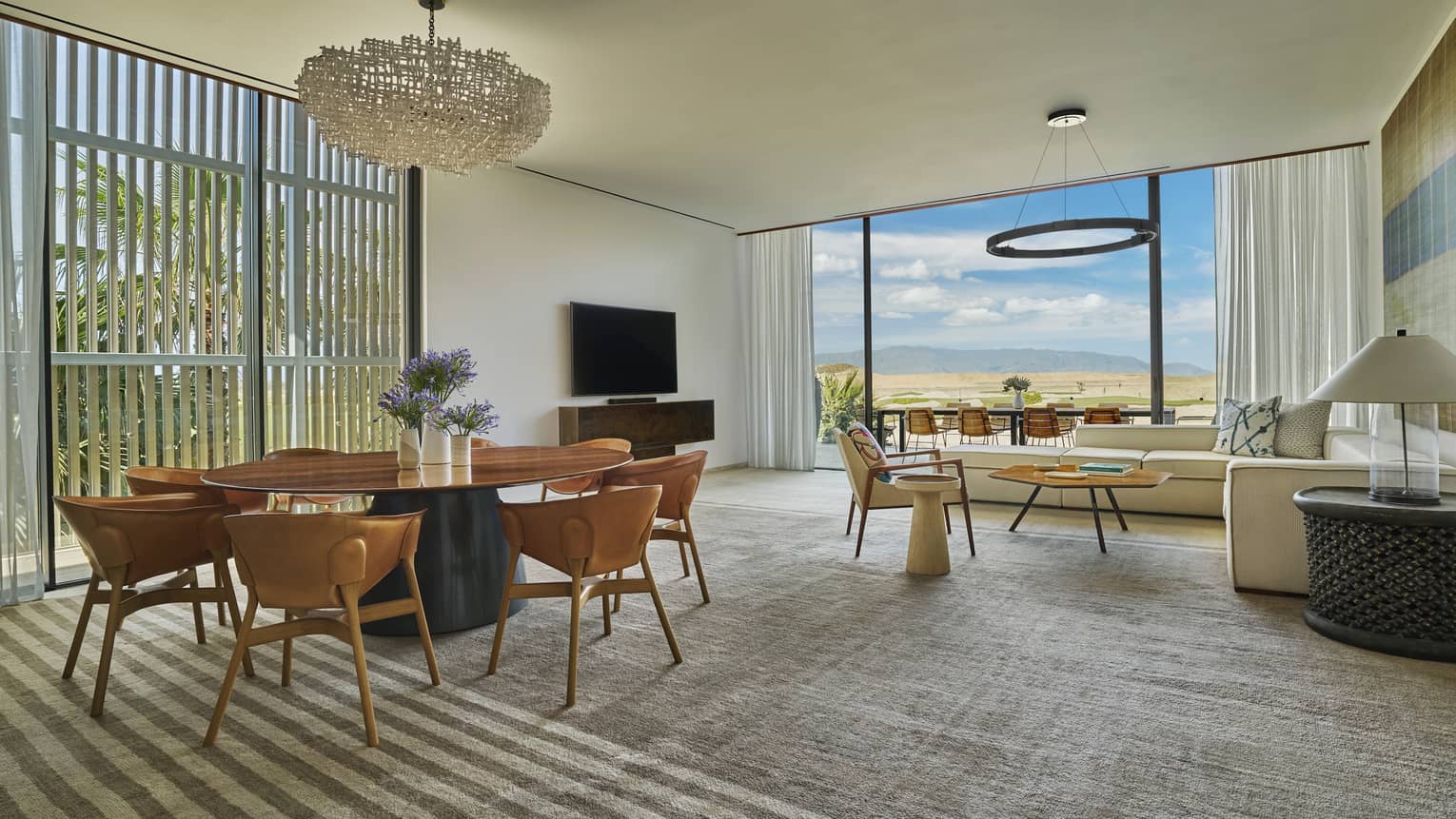 Spacious living room and contemporary, circular dining table of private luxury villa at Four Seasons Resort and Residences Los Cabos