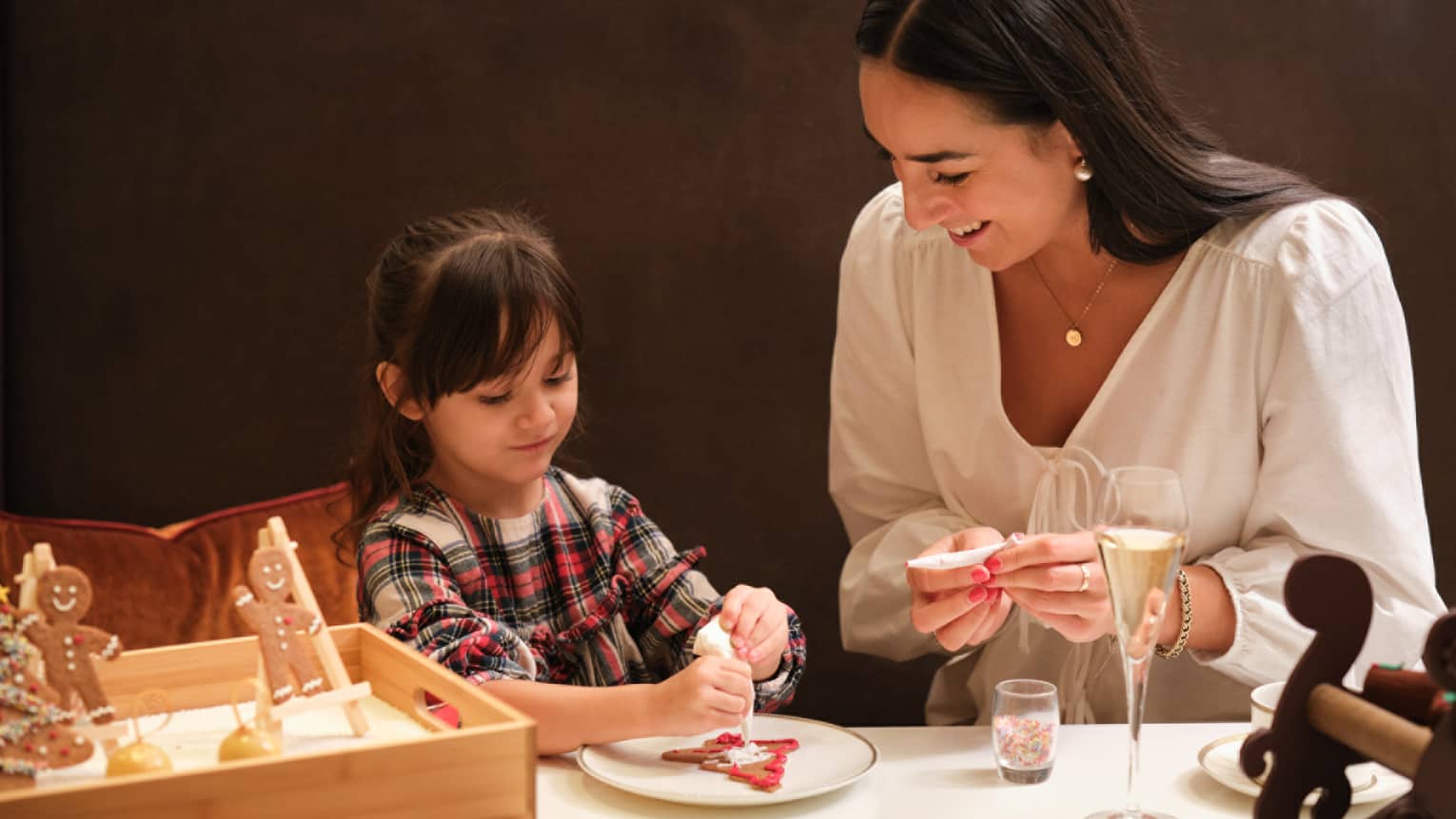Woman and young girl decorate Christmas cookies
