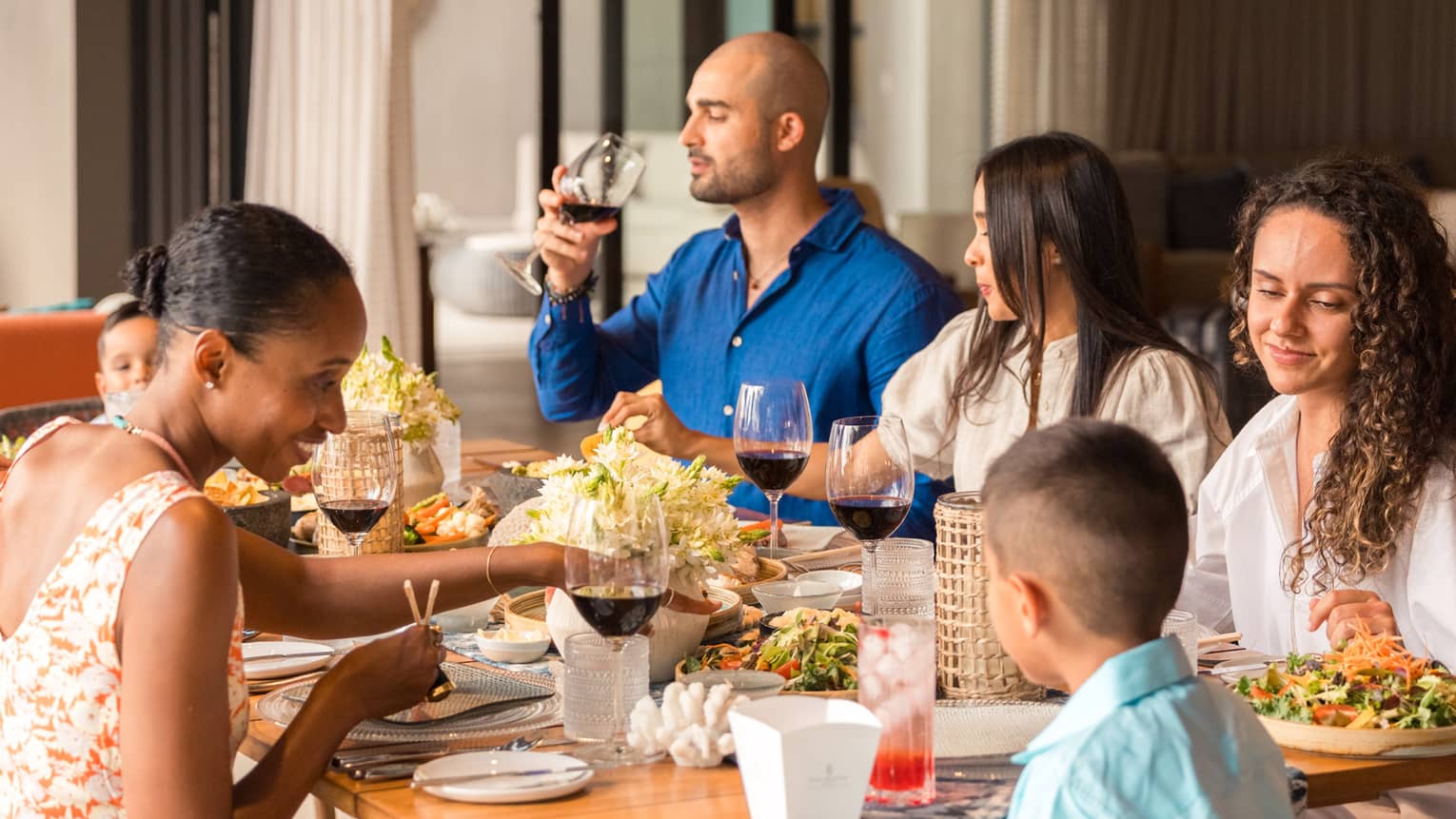 Family dines together at an outdoor table set on a private villa terrace