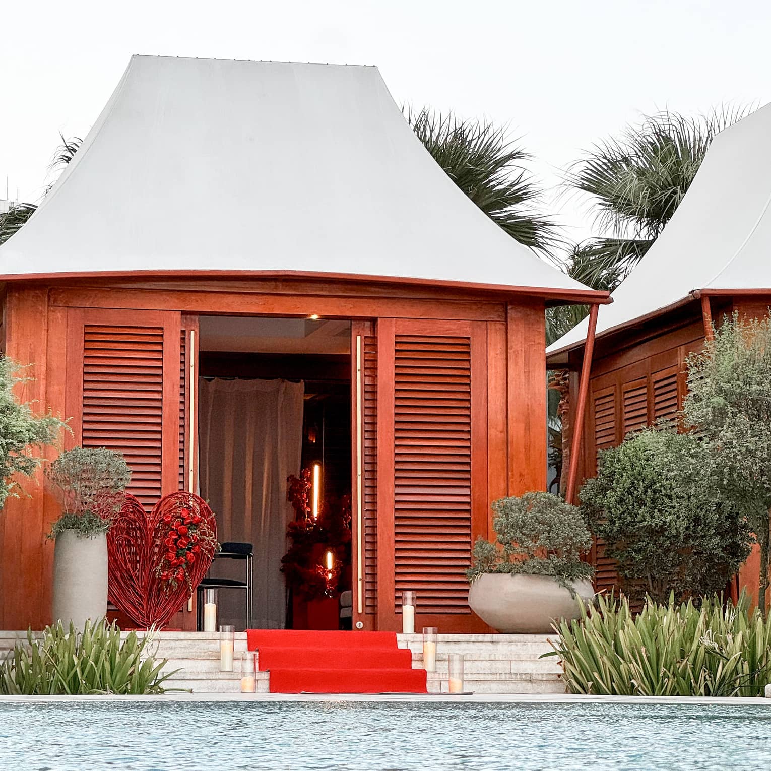 Poolside cabana with red carpet leading up to the entrance