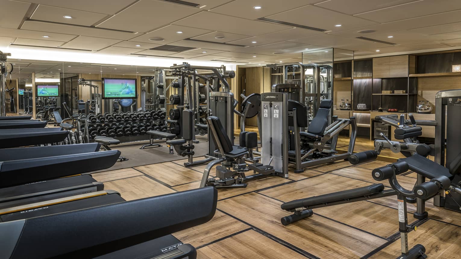 Hotel fitness centre and gym with cardio equipment, weightlifting machines and free weights station