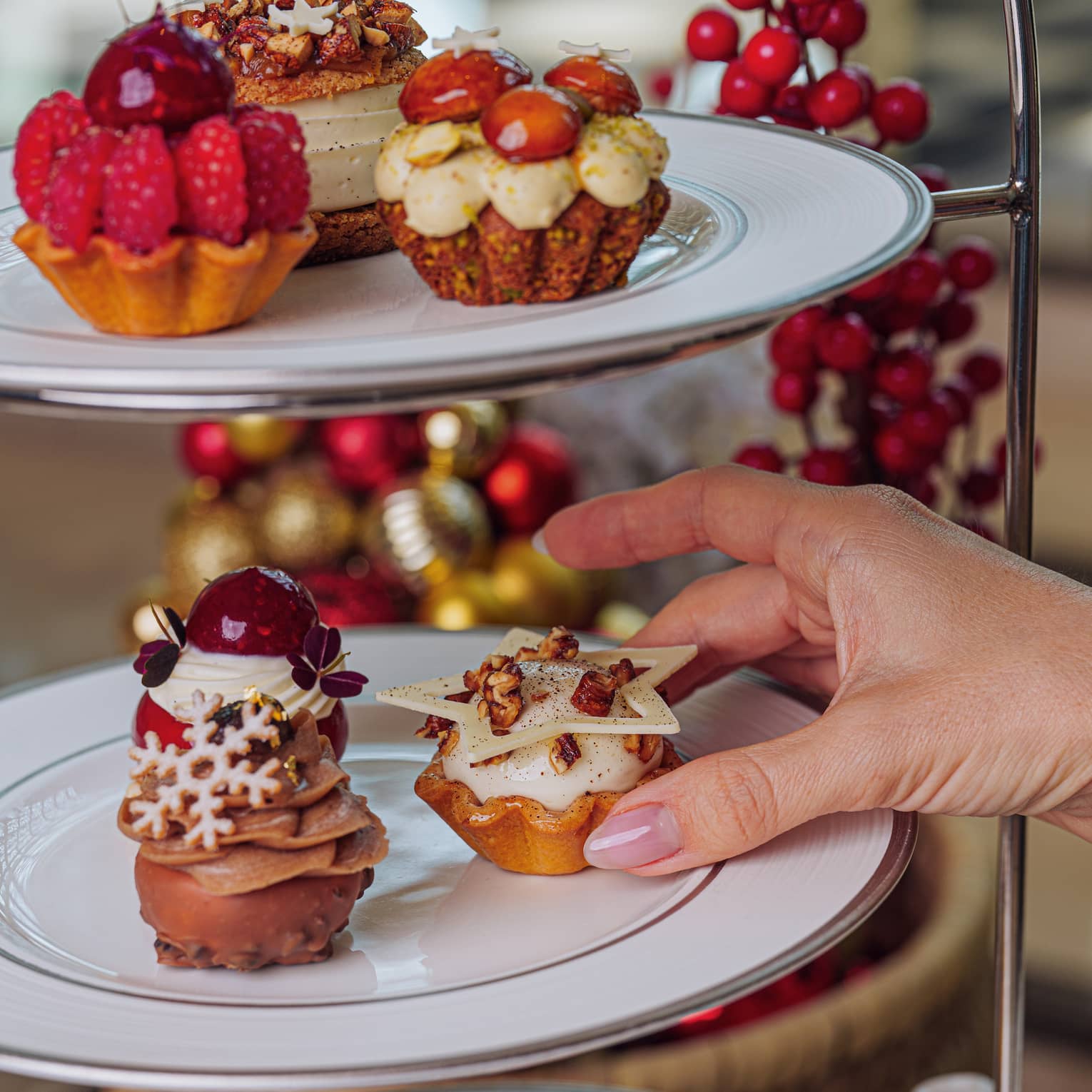 Three-tiered tray of holiday-themed afternoon tea pastries
