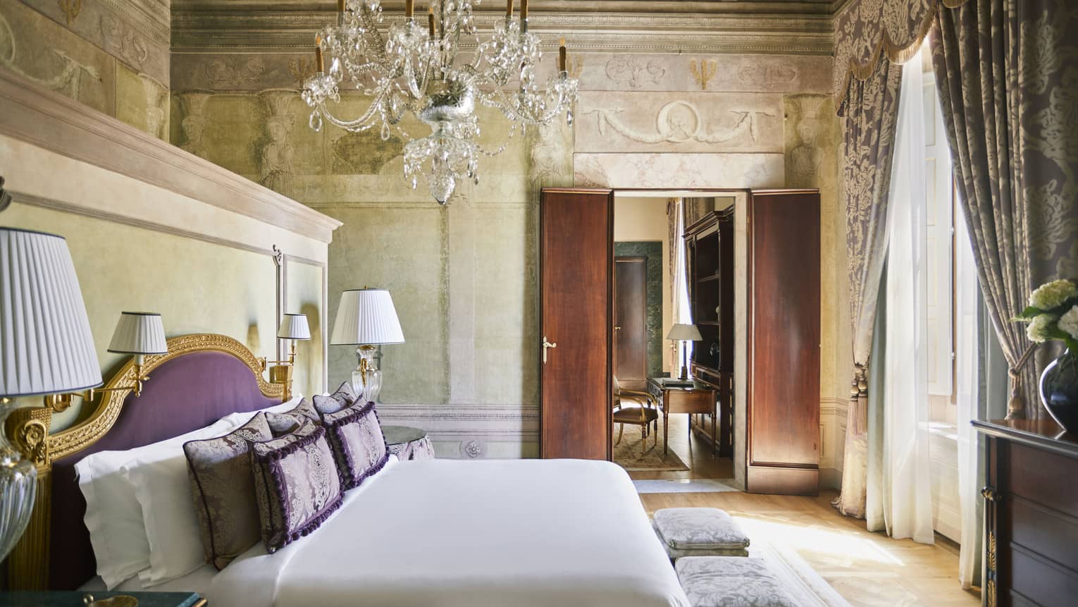 Frescoed Executive Suite bedroom with king bed and crystal candelier at Four Seasons Hotel Florence