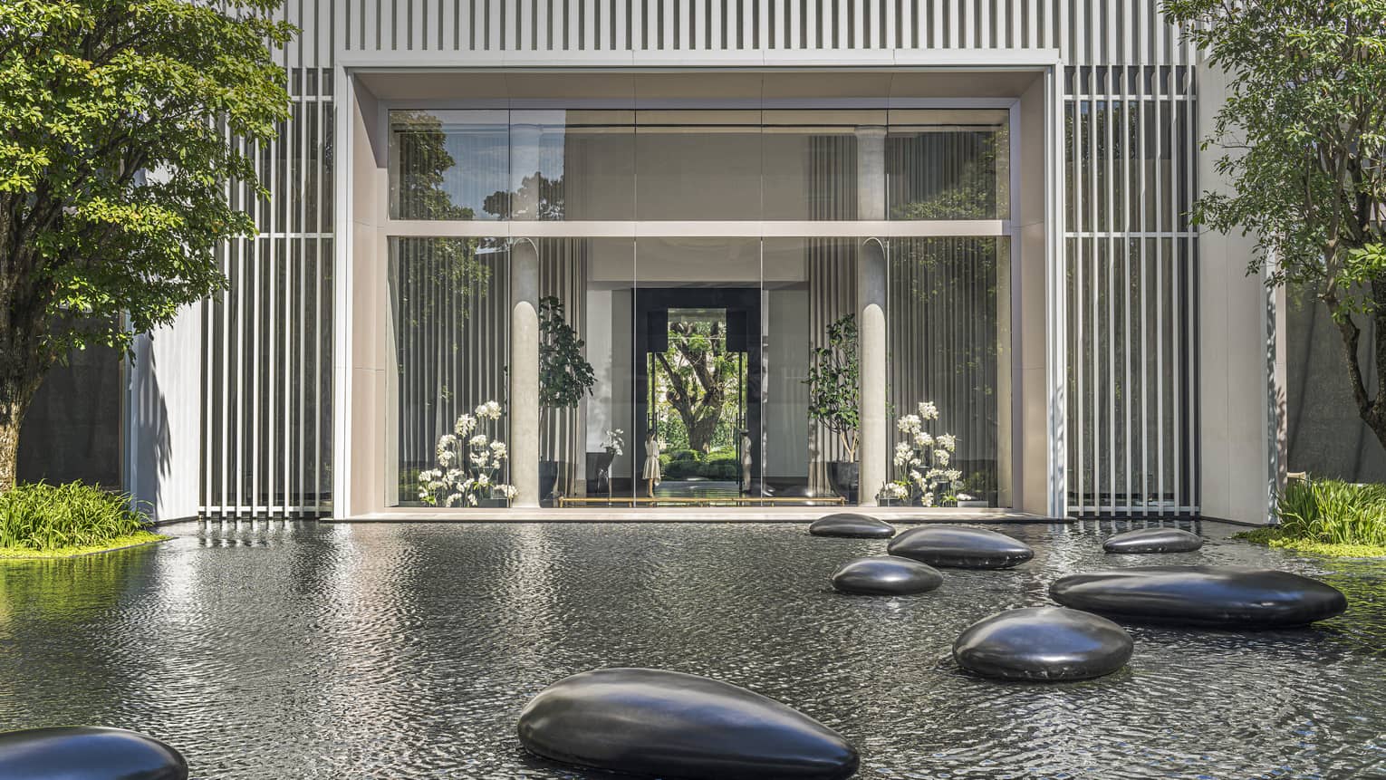 Calm pond in front of hotel with large polished stones scattered throughout