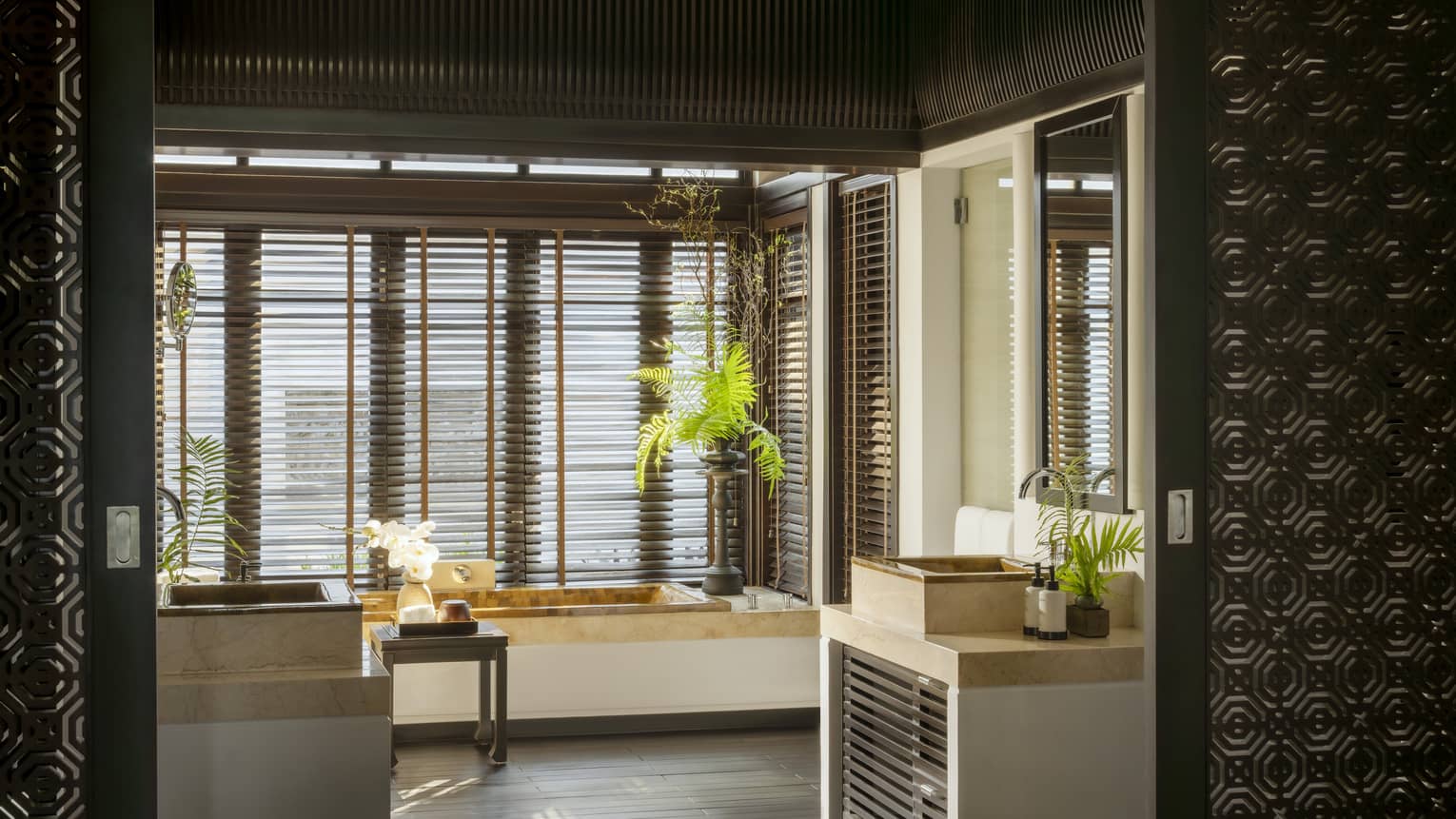 Luxury villa bathroom with tub and shuttered window