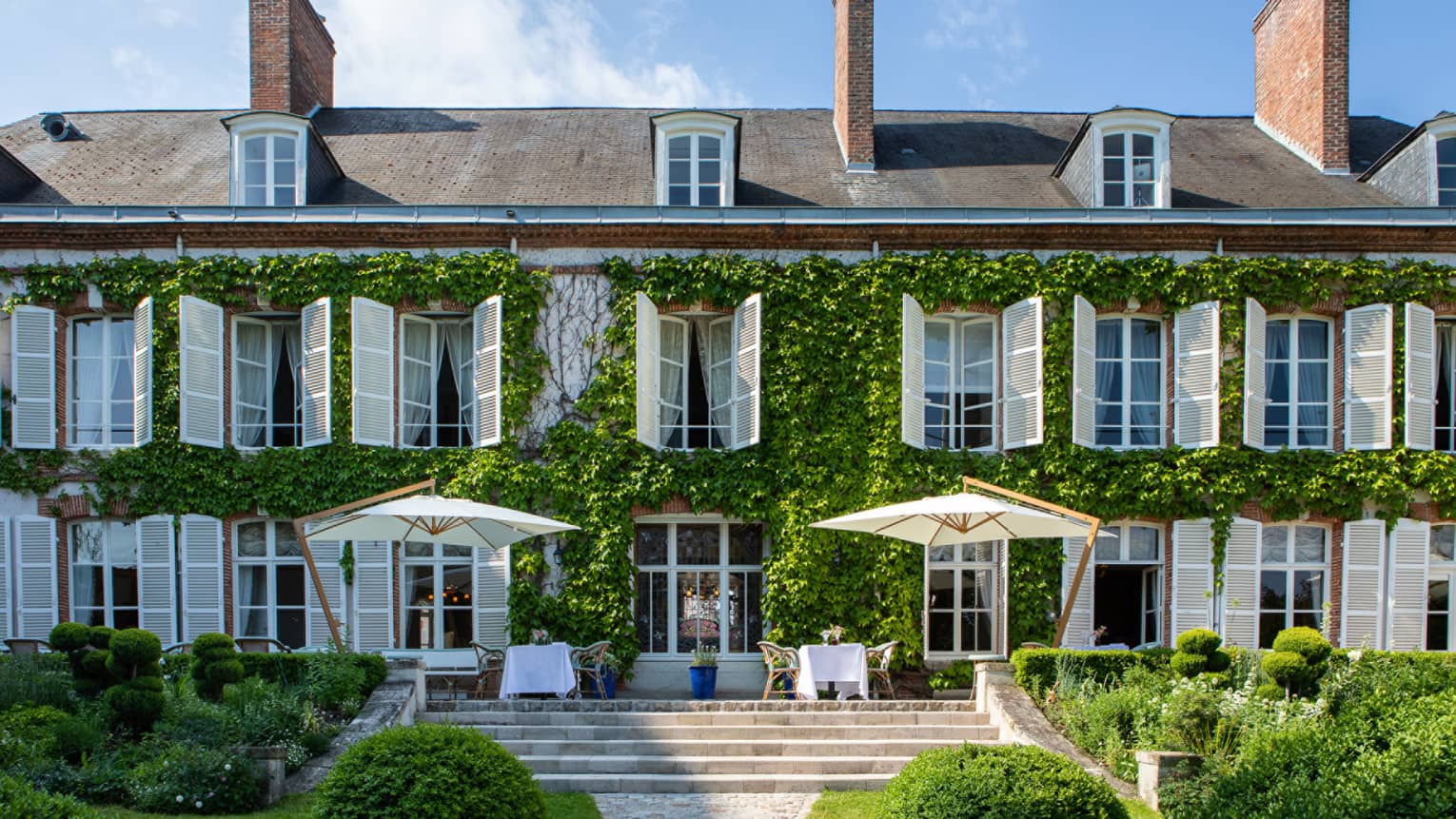 Exterior of the Maison Belle �poque 19th-century mansion with white shutters surrounded by ivy