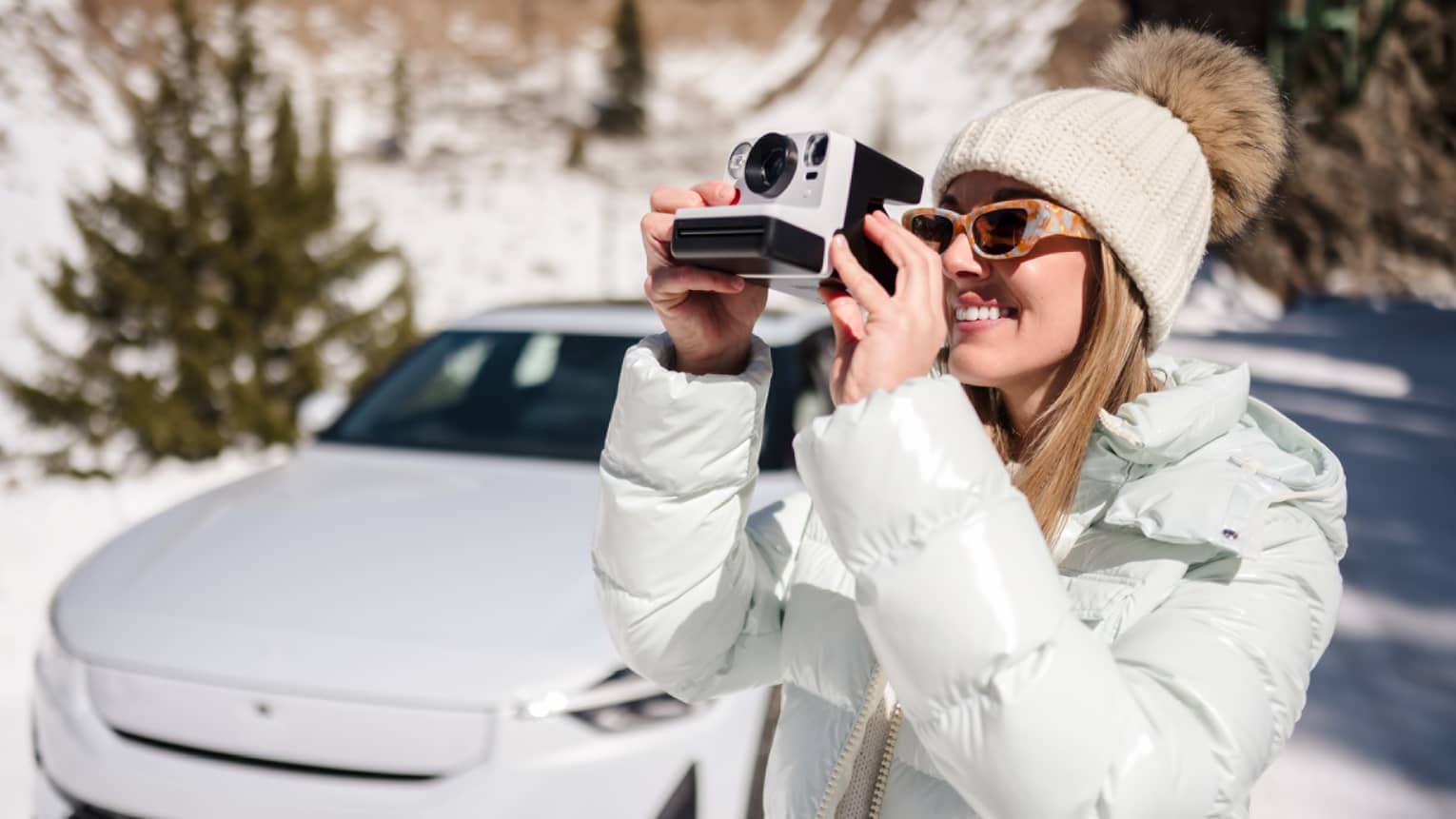 Guest wearing a coat while taking a picture with a camera outside in the snow.