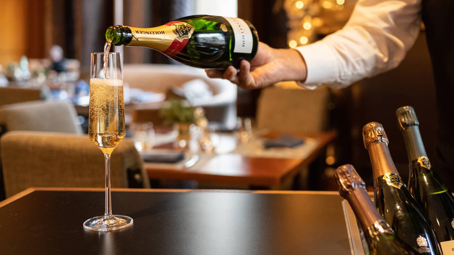 Waiter pours Champagne into a flute