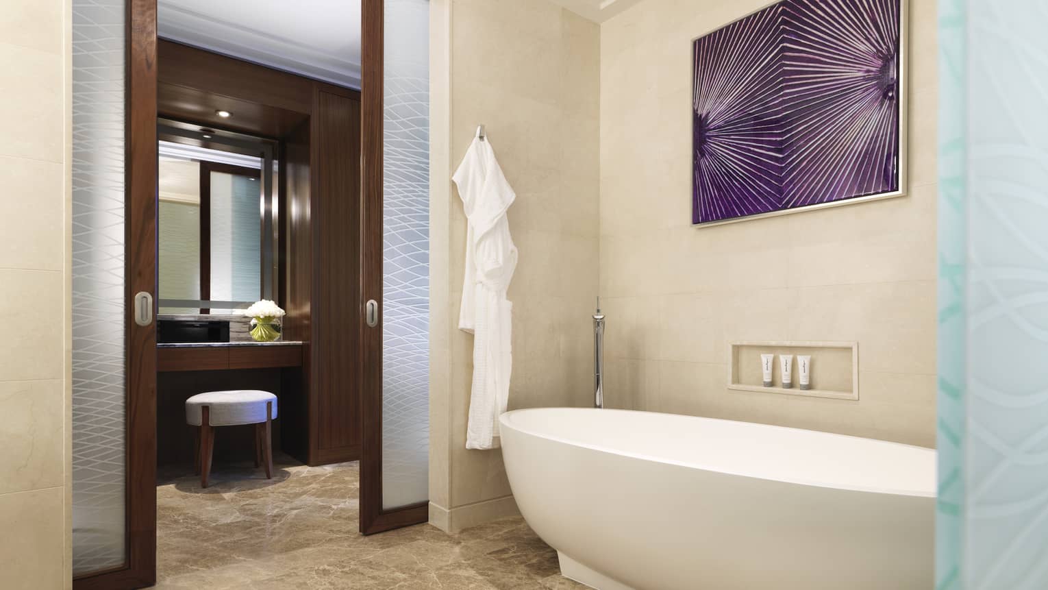 Luxurious bathroom with a freestanding bathtub, sliding frosted glass doors, marble flooring and vibrant purple wall art