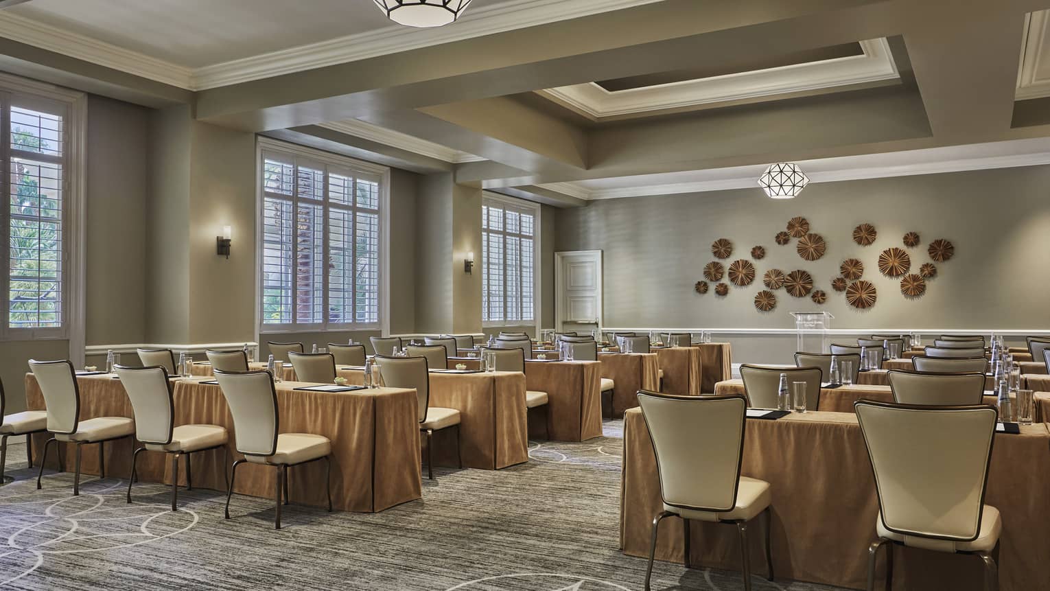 Palm Room conference, rows of meeting tables and chairs facing decorative wall